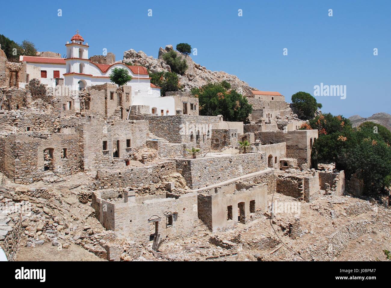 The church of Agia Zoni stands in the ruins of the abandoned village of Mikro Chorio on the Greek island of Tilos. Stock Photo