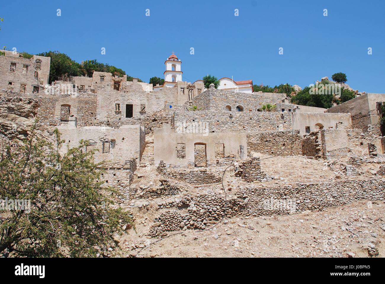 The church of Agia Zoni stands in the ruins of the abandoned village of Mikro Chorio on the Greek island of Tilos. Stock Photo