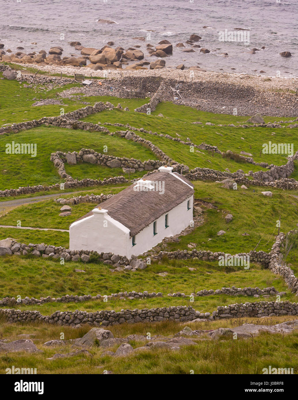 FORELAND HEIGHTS, DONEGAL, IRELAND - Cottage and stone walls on coast. Stock Photo
