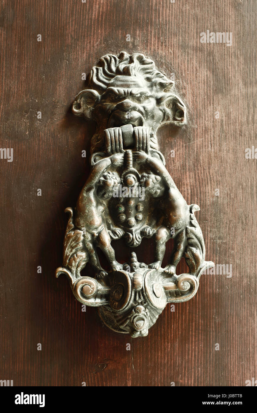 An antique pull handle knob on a vintage wooden door. Architecture in
