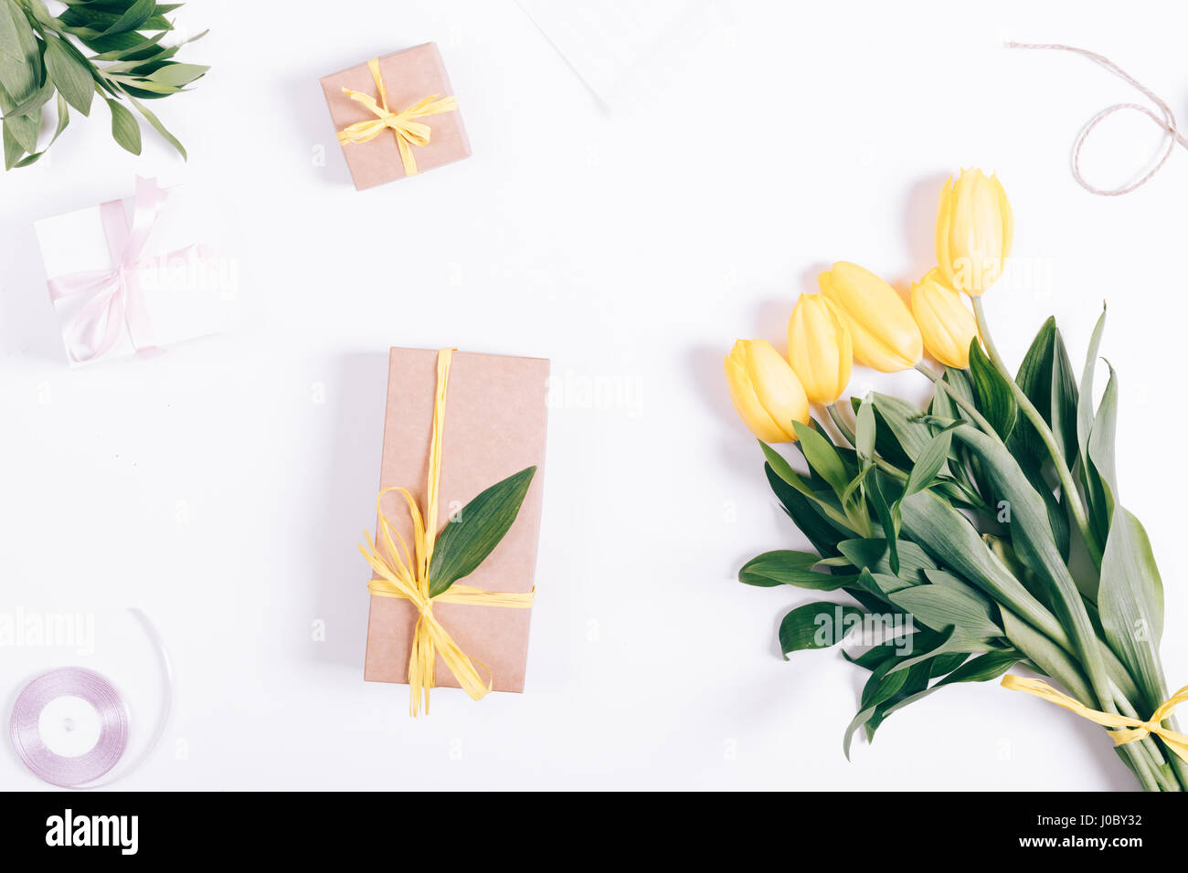 Yellow tulips and gift box lying on white background, top view Stock ...
