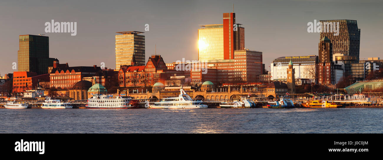 View from Elbe River to St. Pauli Landungsbruecken pier and skyscraper Tanzende Tuerme at sunset, St. Pauli, Hamburg Stock Photo