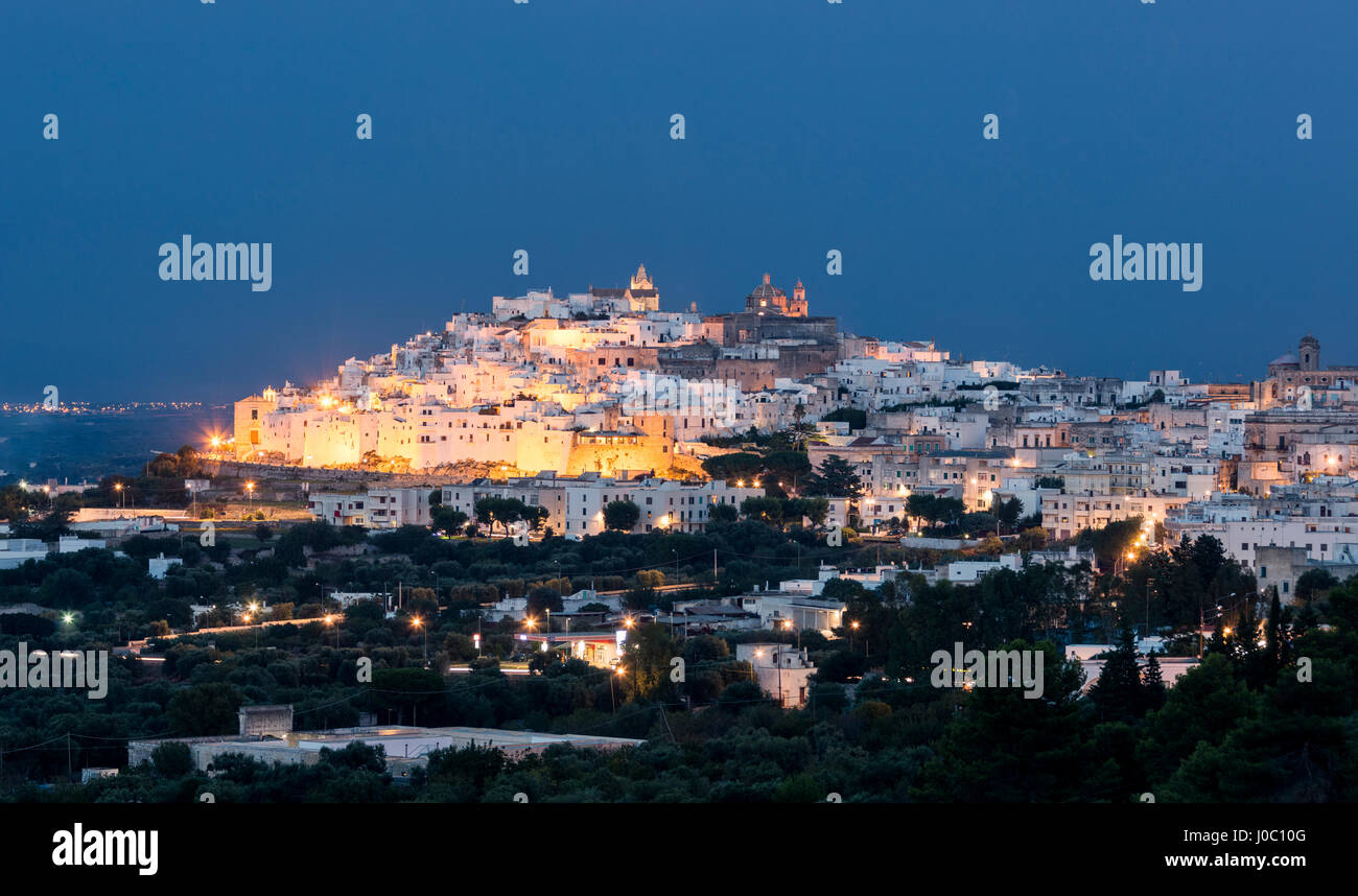 View of typical architecture and white houses of the old medieval town at dusk, Ostuni, Province of Brindisi, Apulia, Italy Stock Photo