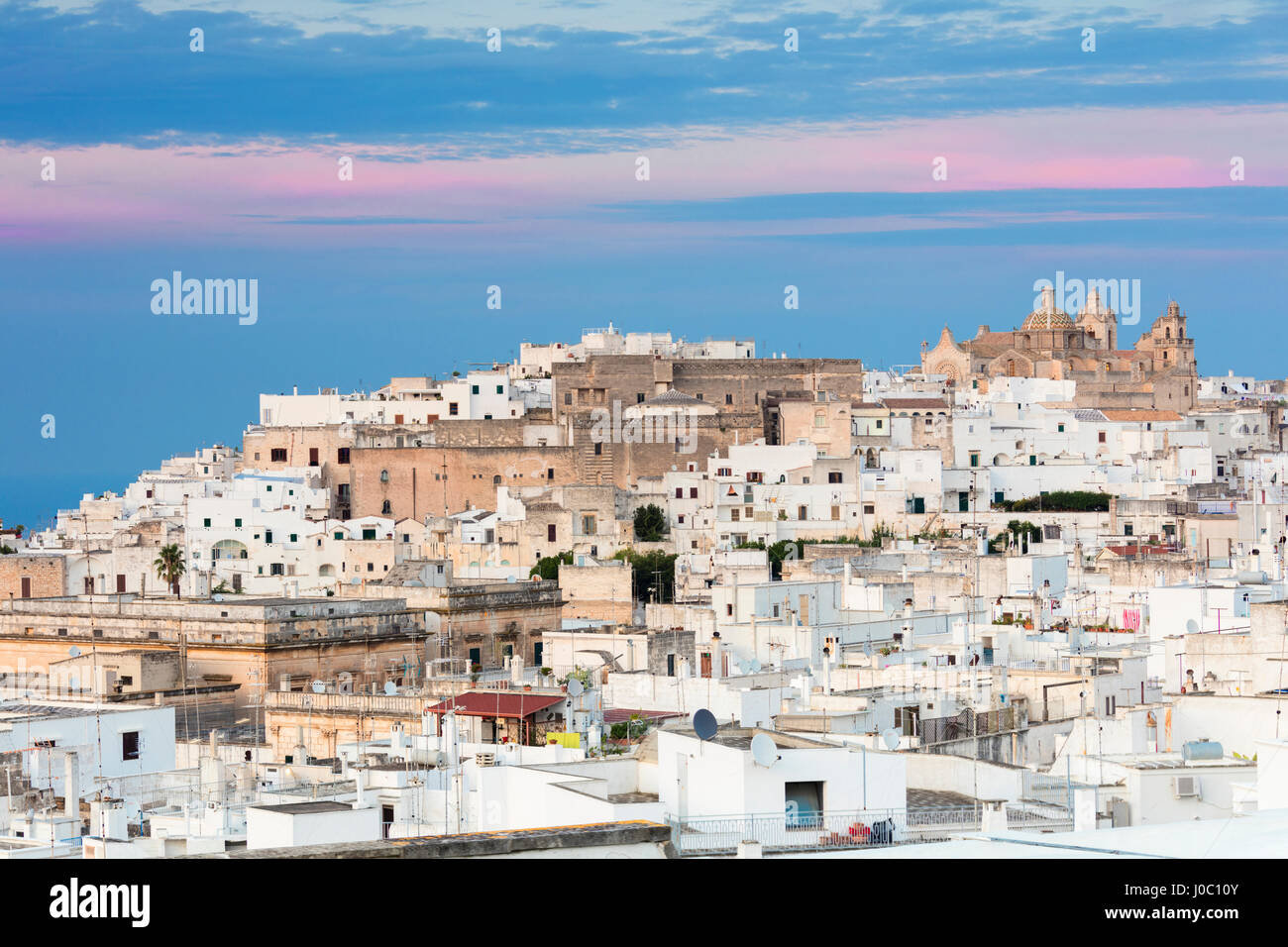 View of typical architecture and white houses of the old medieval town at sunset, Ostuni, Province of Brindisi, Apulia, Italy Stock Photo