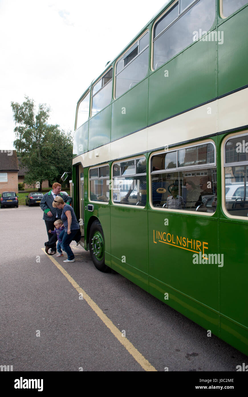 Green vintage 1955 Bristol Lodekka LD6B bus with Lincolnshire on the side with bus driver stood by the door and a woman and her child getting off Stock Photo