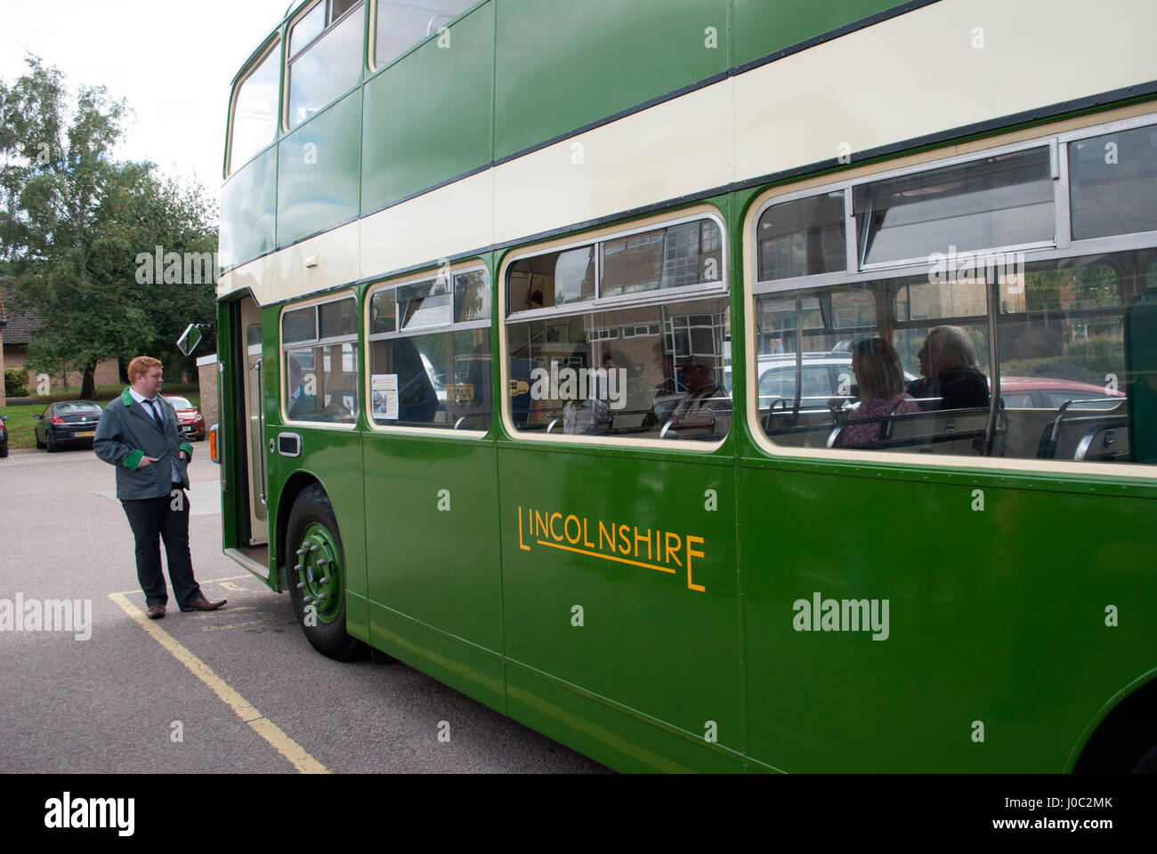Green vintage 1955 Bristol Lodekka LD6B bus with Lincolnshire on the side with bus driver in grey jacket and green trim stood by the door Stock Photo
