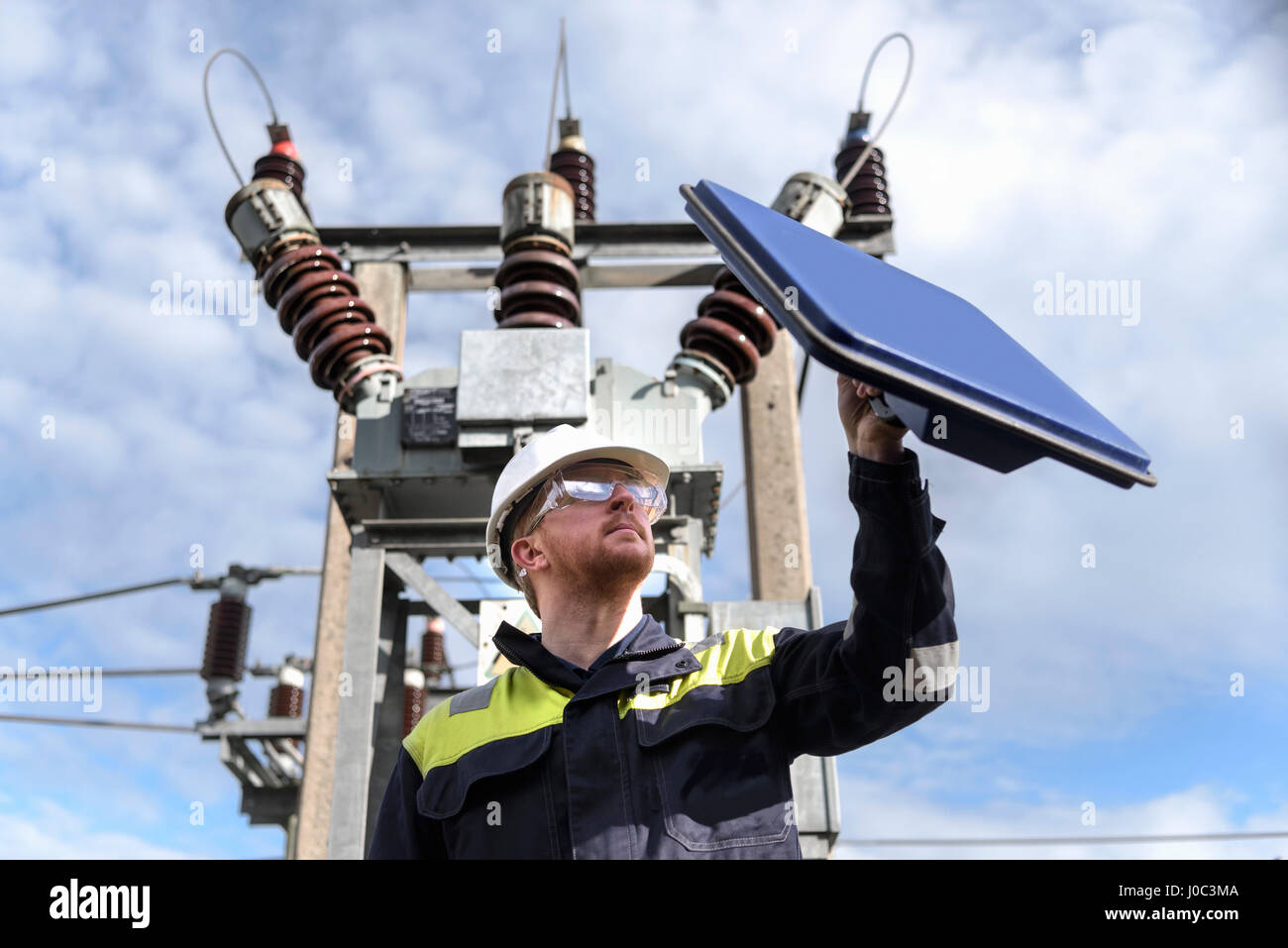 Worker using partial discharge detector in electricity substation Stock Photo