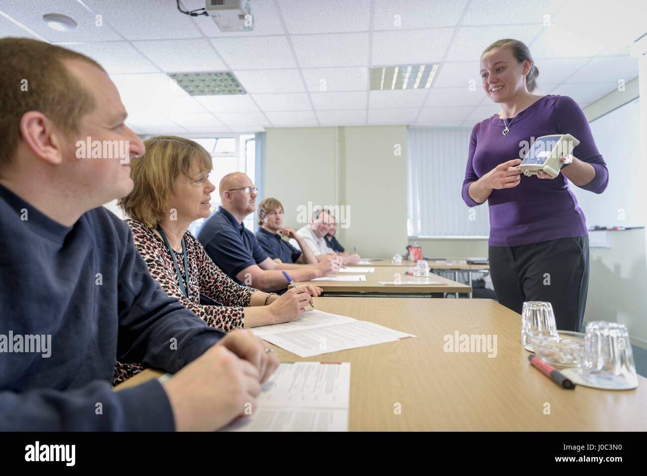 Seminar leader instructing staff members about electrical components Stock Photo