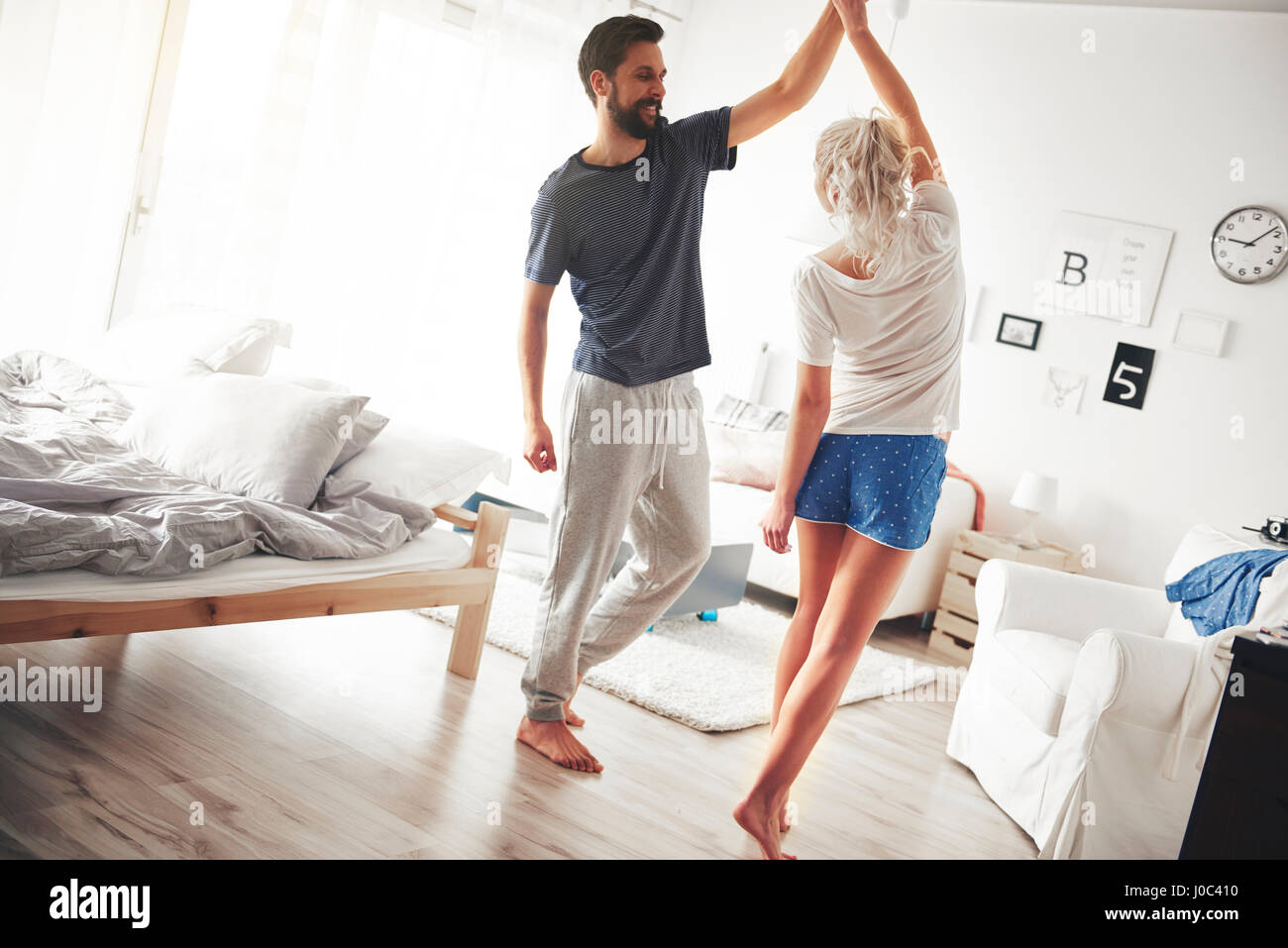 Couple in bedroom, wearing pyjamas, dancing Stock Photo