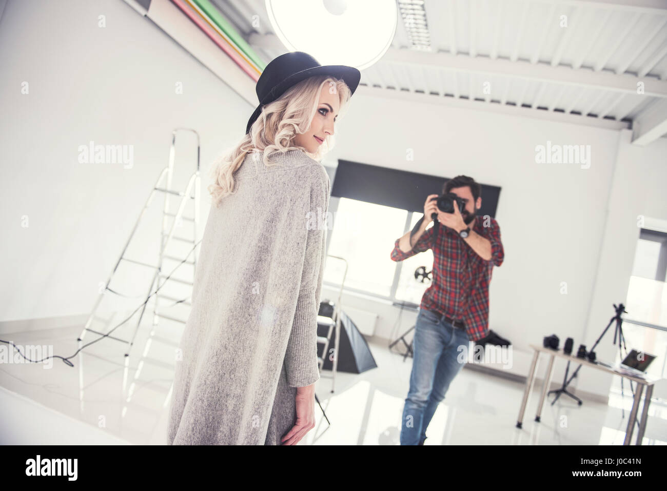 Male photographer photographing female model on studio white background Stock Photo
