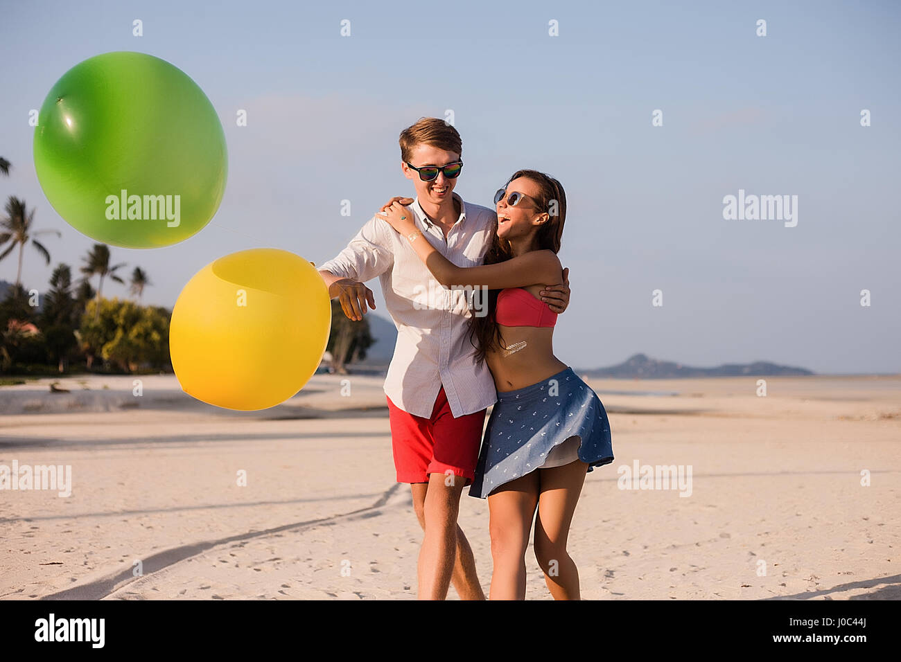 Young couple on beach playing with balloons, Koh Samui, Thailand Stock Photo