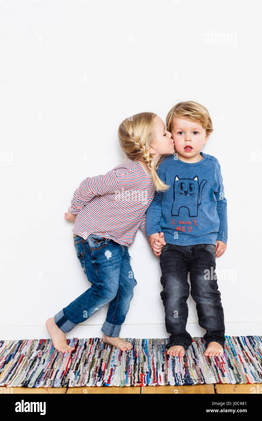 Young girl kissing young boy on cheek Stock Photo