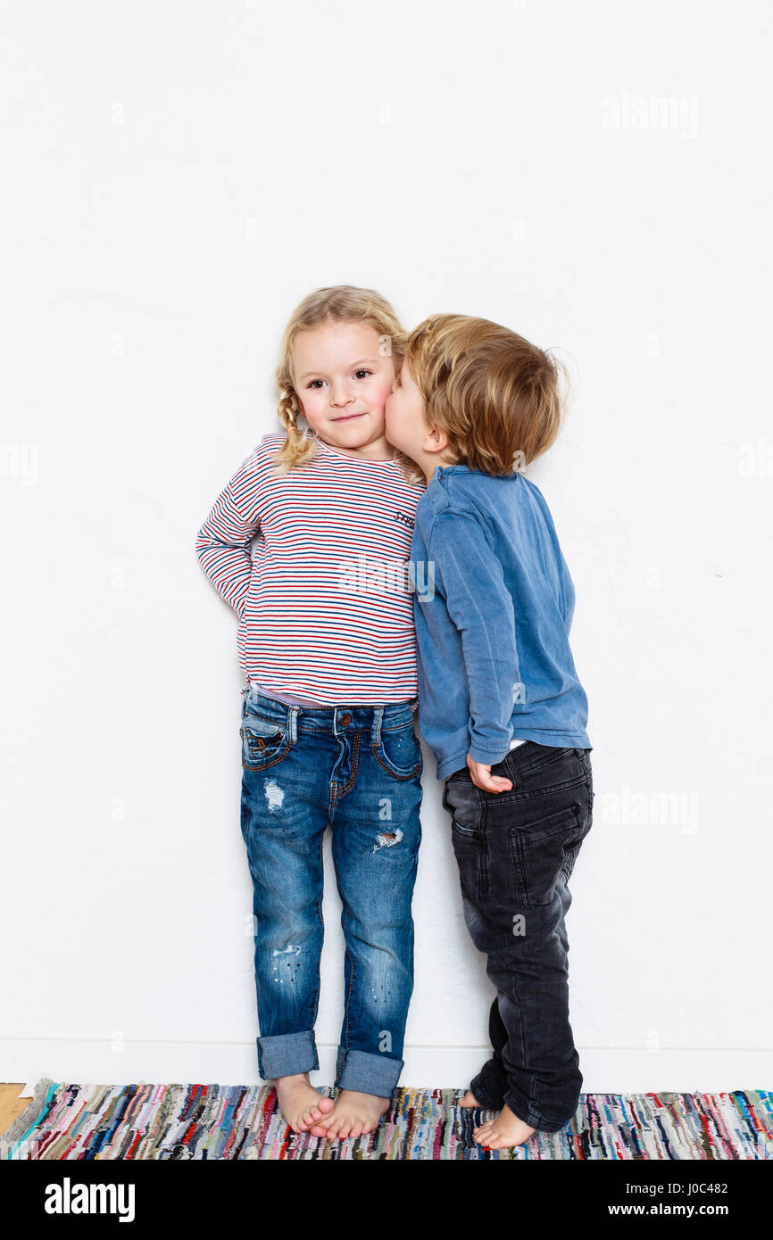 Young boy kissing young girl on cheek Stock Photo