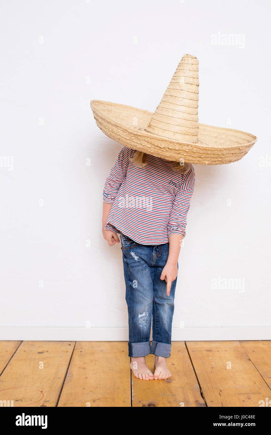 Young girl, wearing sombrero, pointing to feet Stock Photo