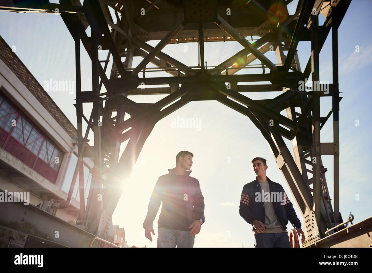 Two young men walking under bridge, Bristol, UK Stock Photo