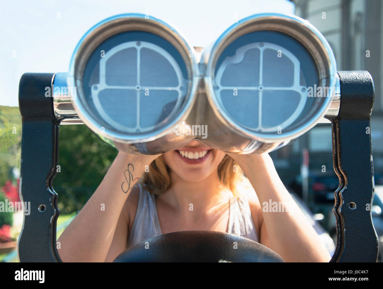 Young woman looking through coin operated binoculars at the Monte dei Cappuccini, Turin, Italy Stock Photo