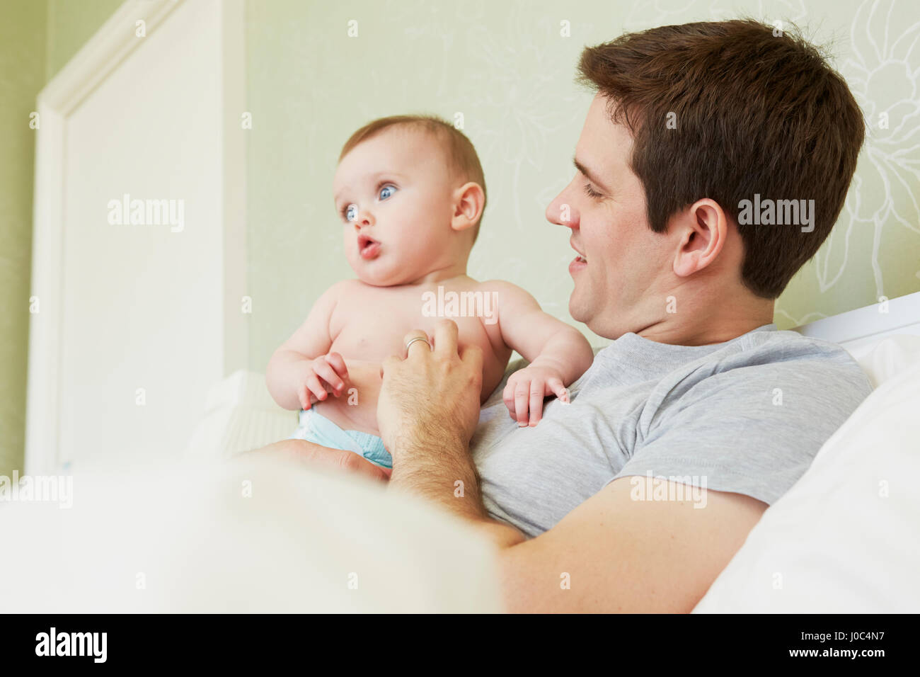 Mid adult man and baby daughter in bed Stock Photo