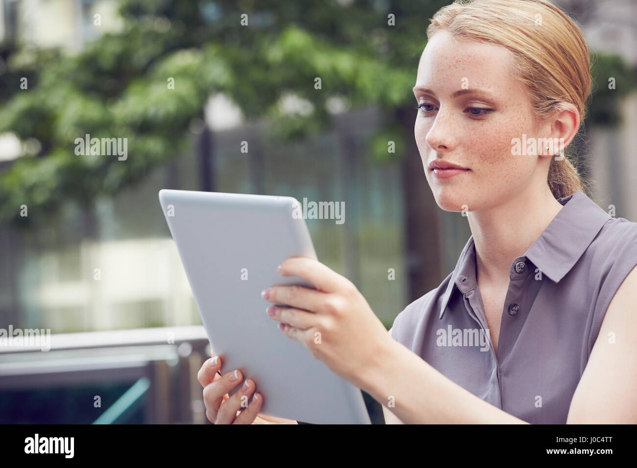 Woman using digital tablet, London, UK Stock Photo