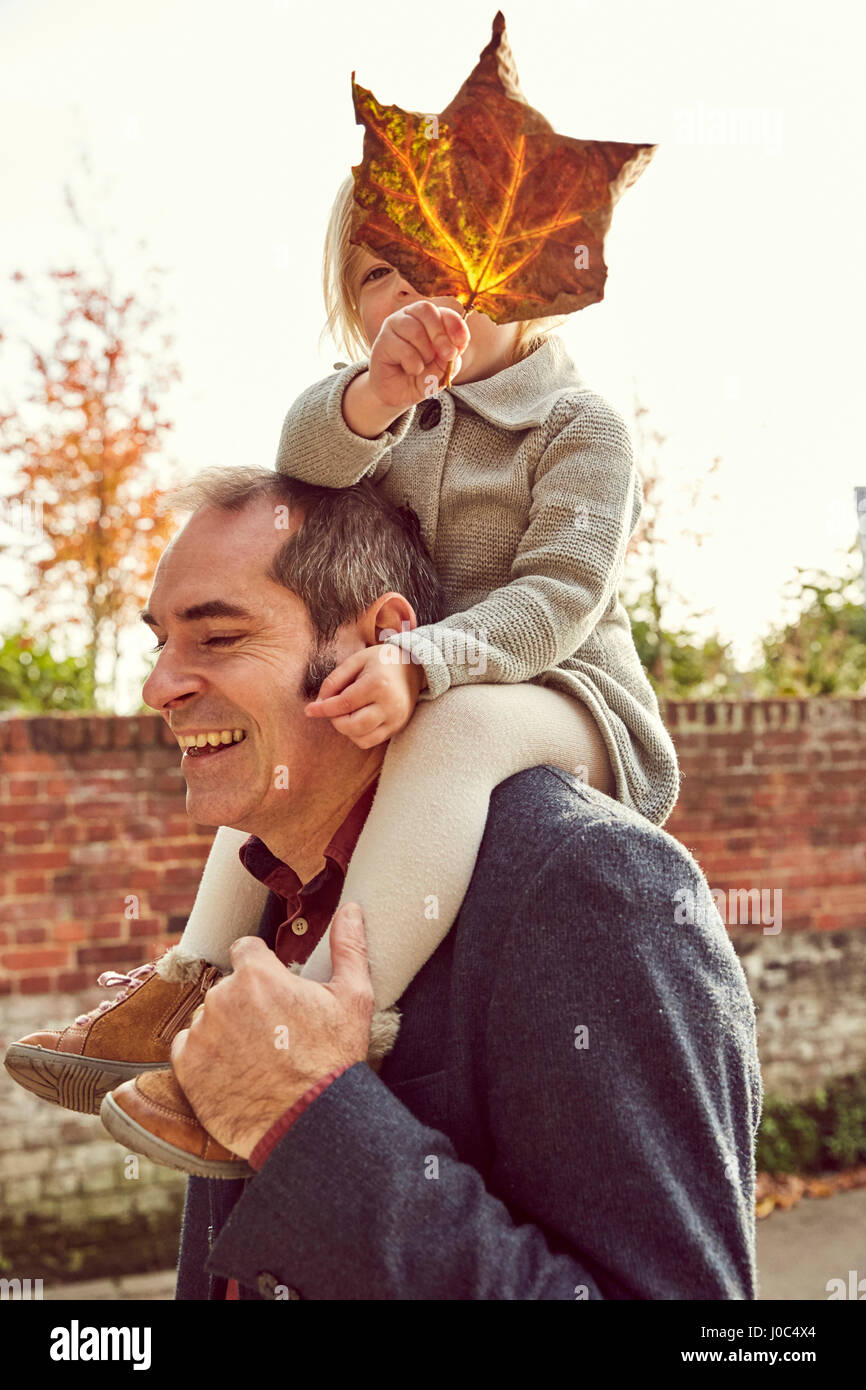 Father carrying daughter on shoulders Stock Photo