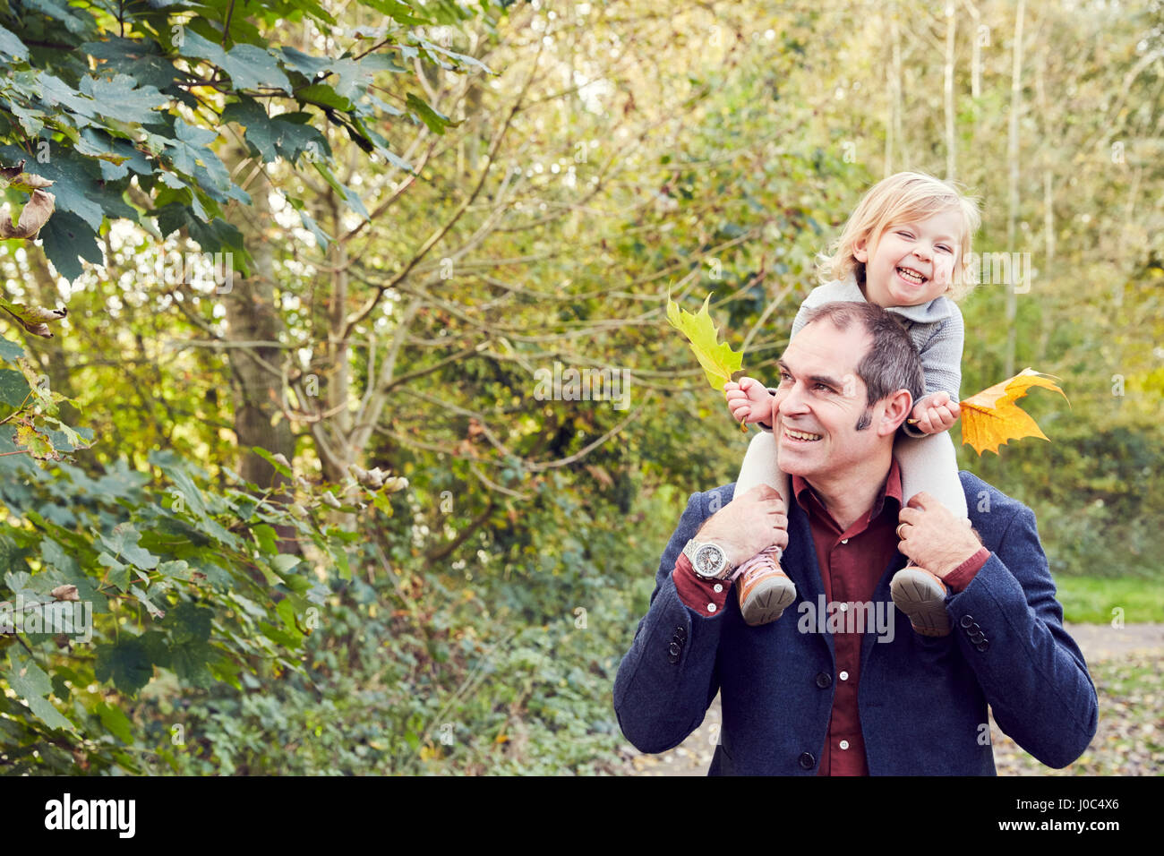 Father carrying daughter on shoulders Stock Photo