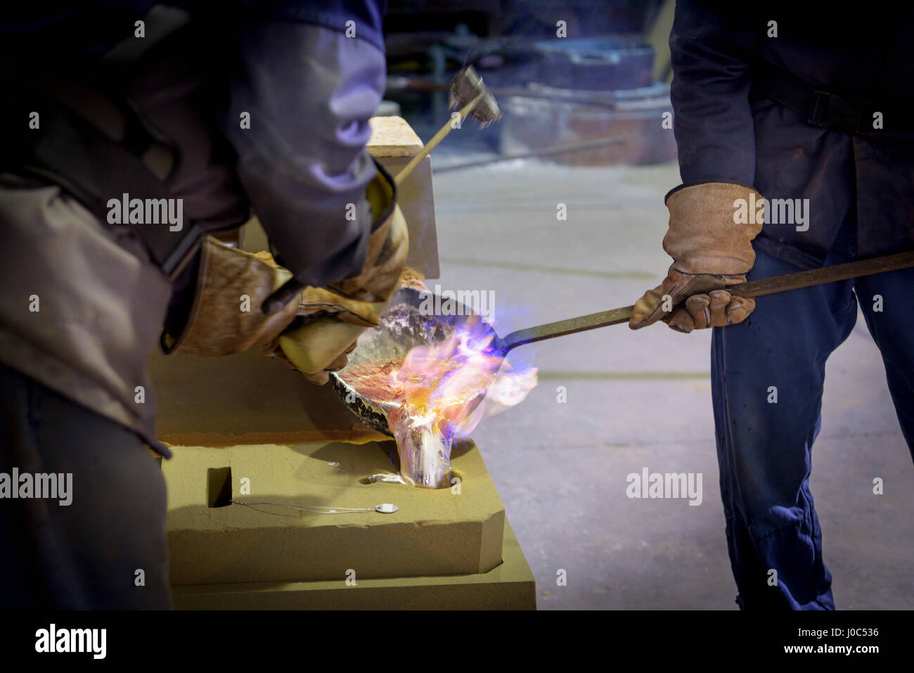 Workers pouring aluminium alloy sample in precision casting factory Stock Photo
