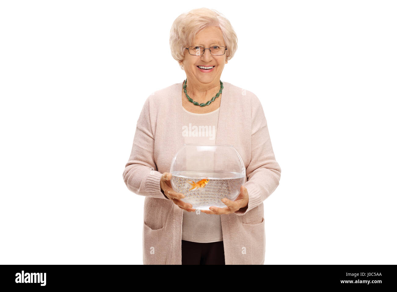 Mature woman holding a bowl with a goldfish inside and looking at the camera isolated on white background Stock Photo