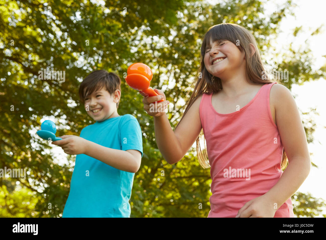 Girl and boy doing egg and spoon race in park Stock Photo Alamy