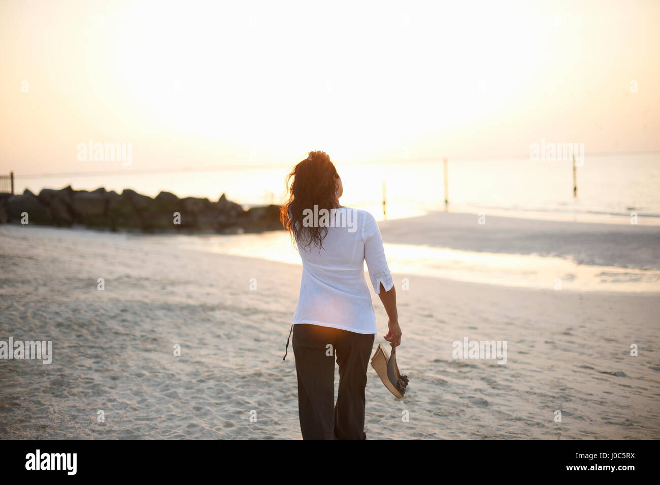 Rear view of woman strolling on beach, Dubai, United Arab Emirates Stock Photo
