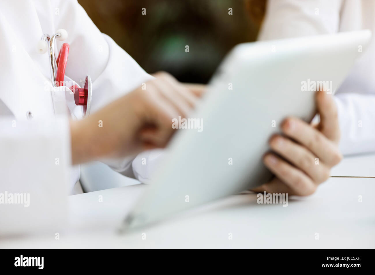Doctor using digital tablet, close-up Stock Photo