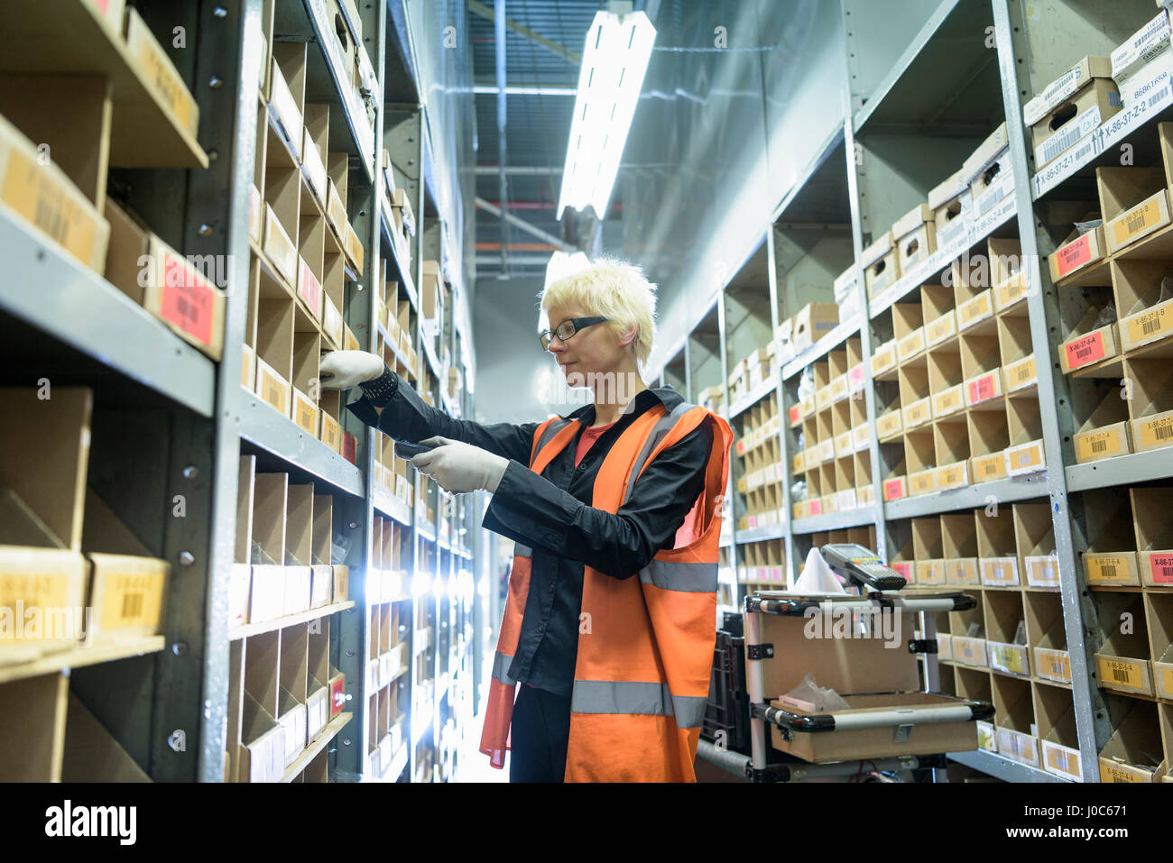 Female apprentice picking parts in car factory Stock Photo
