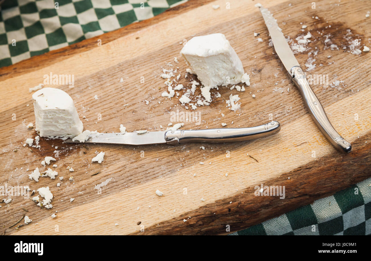 Soft farmers cheese with knives lay on wooden cutting desk, Amsterdam