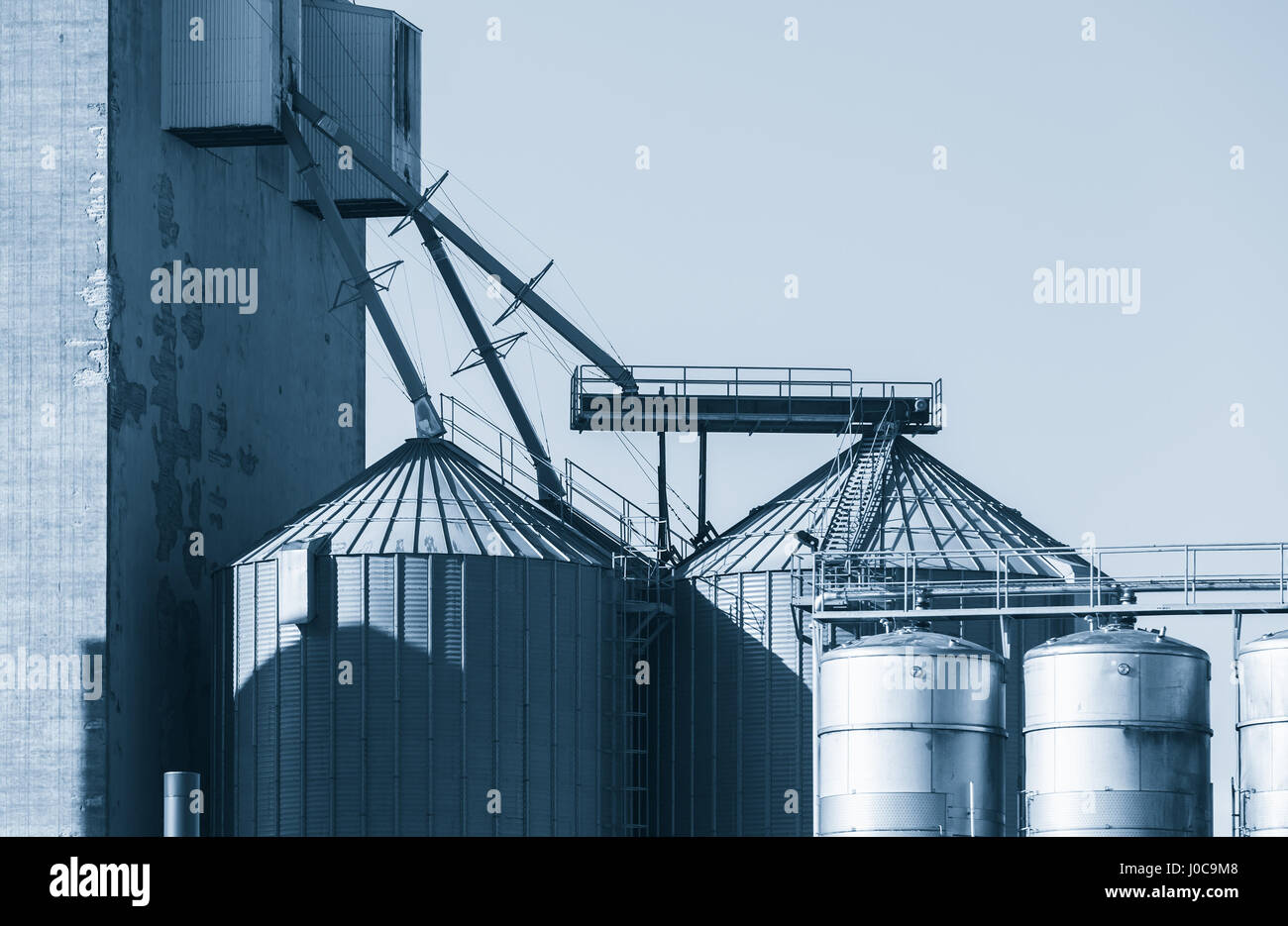 Industrial building with steel tanks, blue toned exterior photo Stock Photo