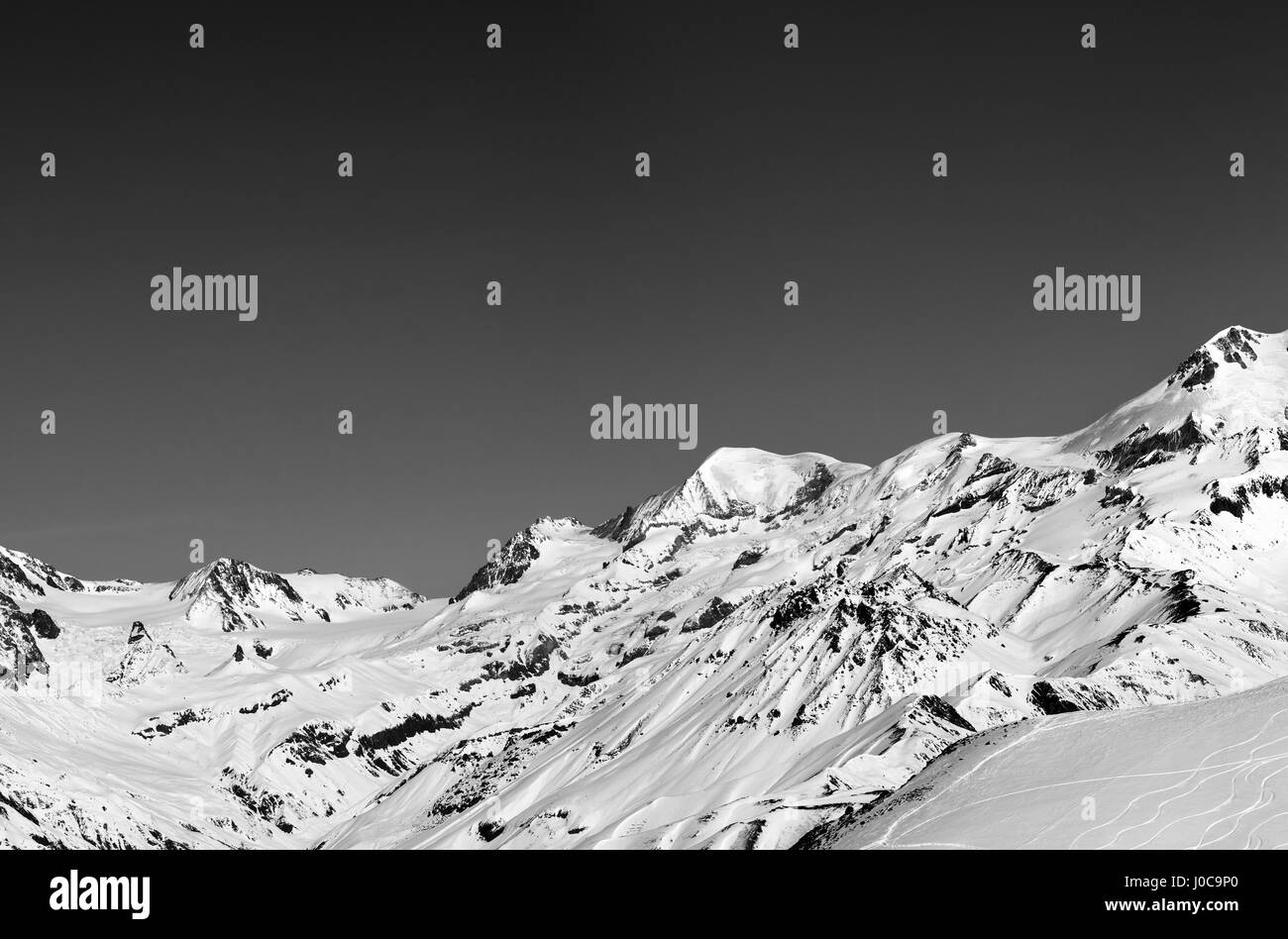 Black and white panoramic view on off-piste slope and snow mountain at sun winter day. Caucasus Mountains, Georgia, region Gudauri. Stock Photo
