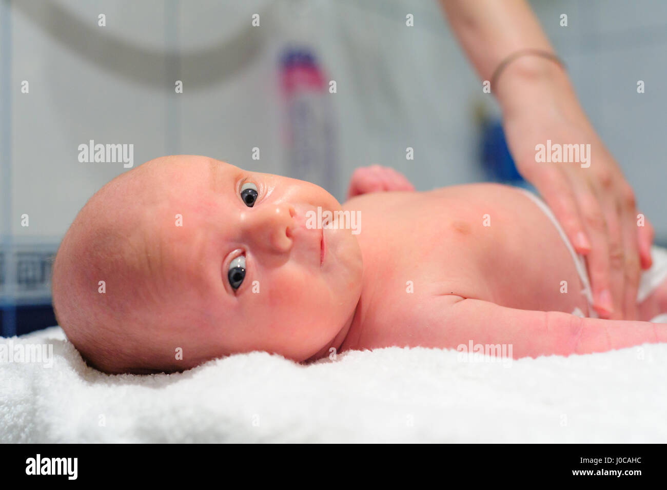 Mom puts a diaper on the baby Stock Photo