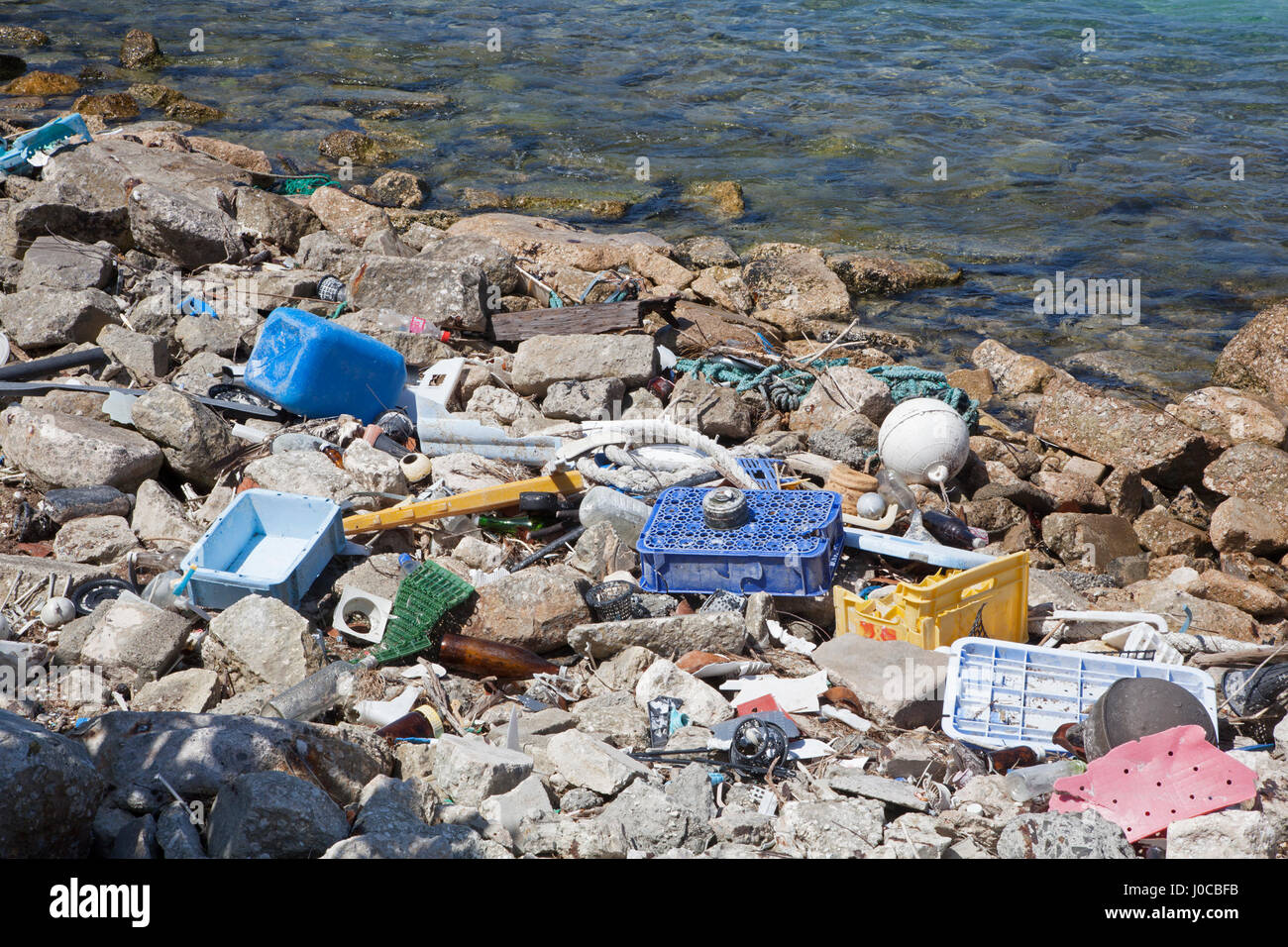 Plastic and glass marine debris washed ashore in the harbor of a North Pacific island Stock Photo