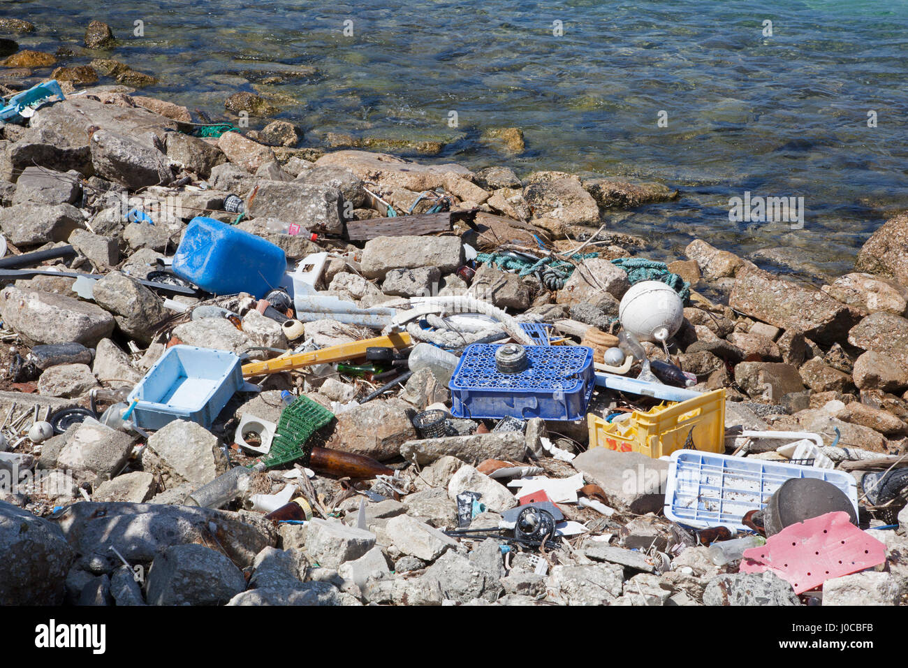 Plastic trash and glass marine debris washed ashore in the harbor of a North Pacific island Stock Photo