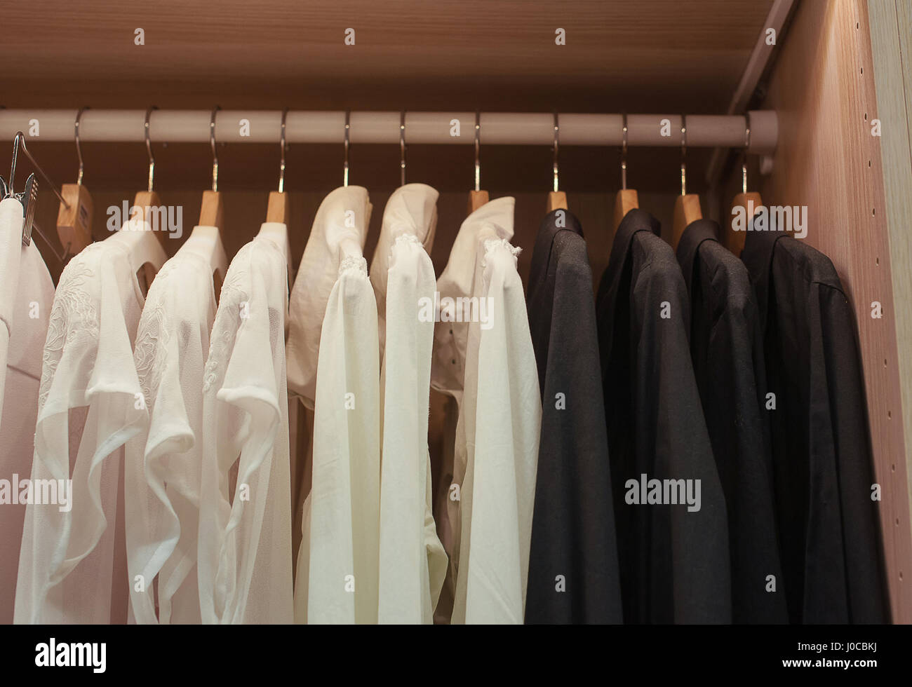 White and black shirts on trempele in the closet Stock Photo