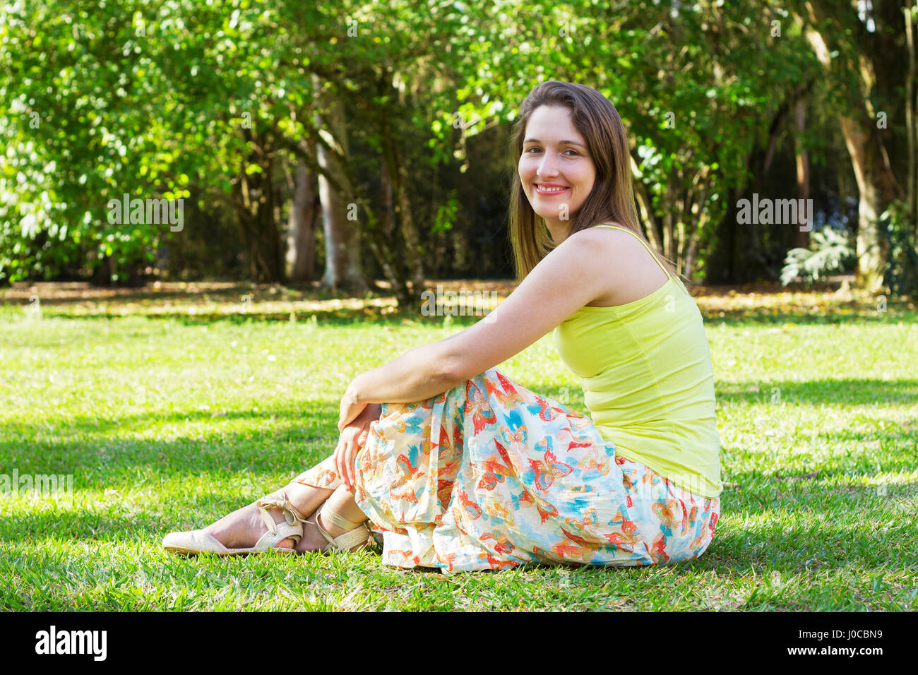 Sitting on the grass in the park Stock Photo - Alamy