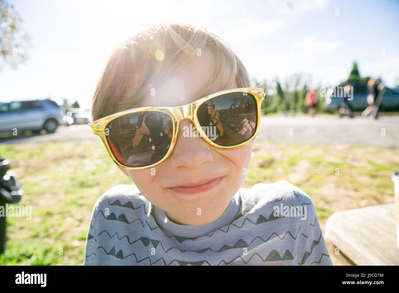 Portrait of cute boy in golden sunglasses in park Stock Photo