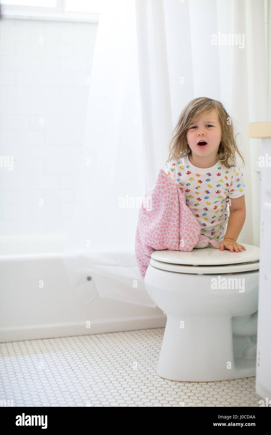 Portrait of girl with messy hair leaning against toilet Stock Photo