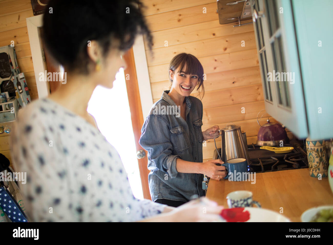 Two friends in kitchen, preparing hot drink Stock Photo - Alamy