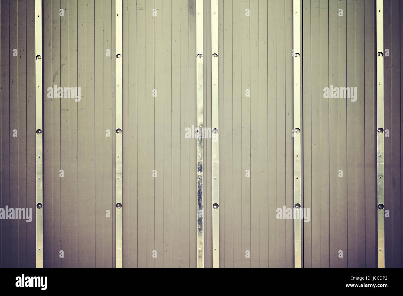Vintage toned picture of lined metal wall, industrial background. Stock Photo
