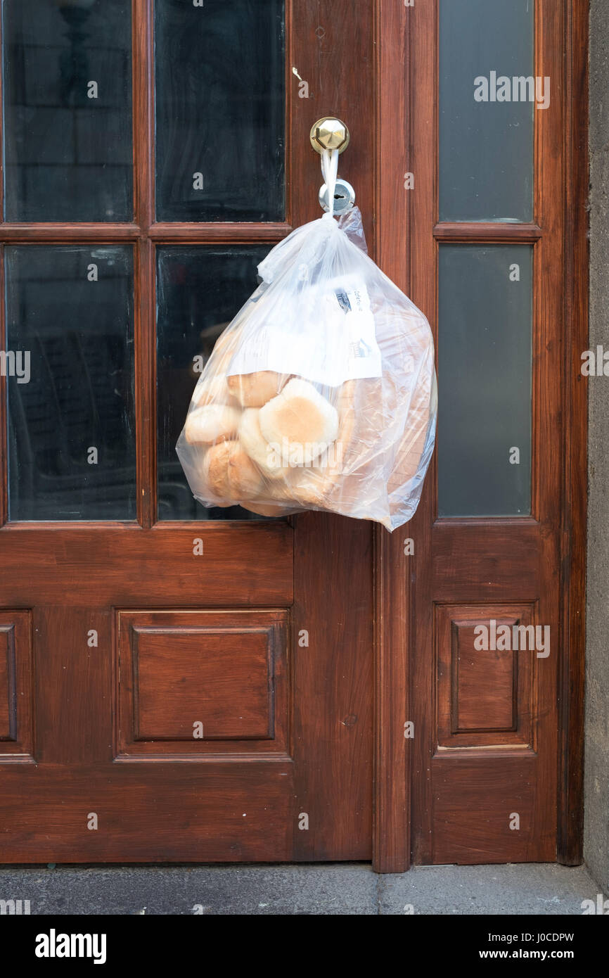 Close up of an early morning fresh bread delivery attached to a door