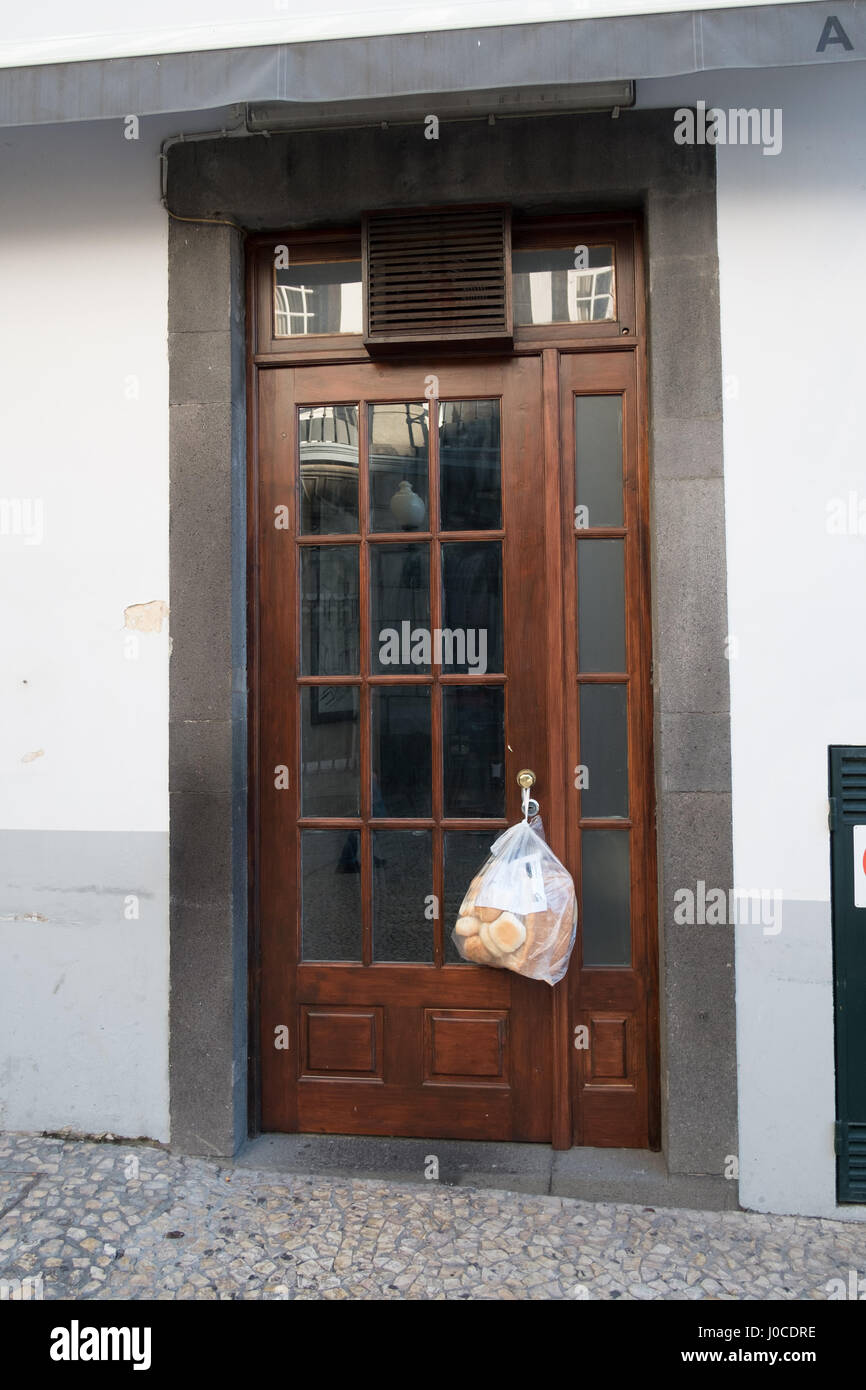Early morning fresh bread delivery attached to a door handle of a
