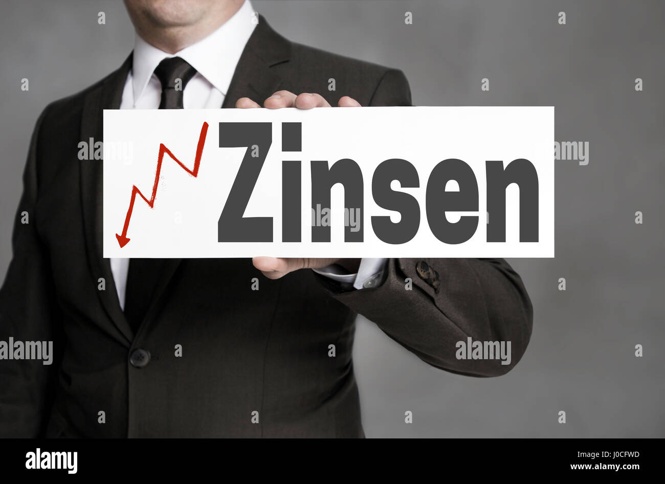 Zinsen (in german Interest) sign is held by businessman. Stock Photo
