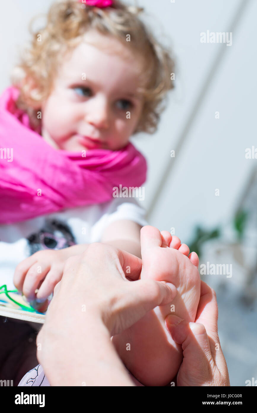 Reflexology foot massage to a female child in naturopath studio Stock