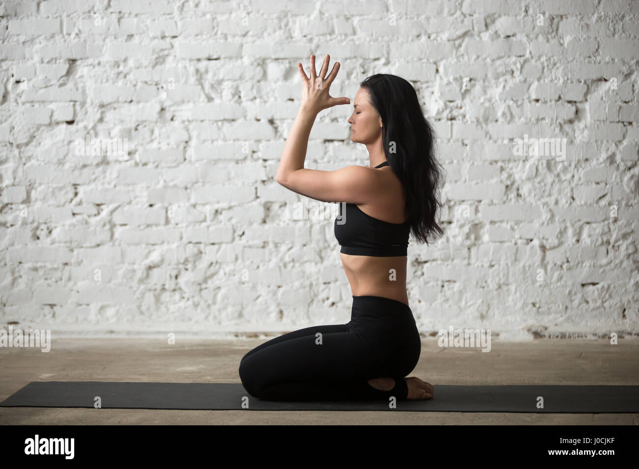 Content sportswoman standing in namaste yoga pose  Free Stock Photo