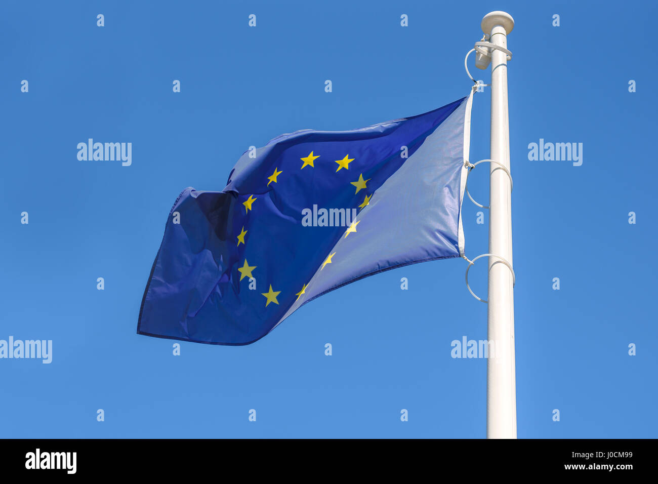 Flag of the European Union waving in the wind on a blue sky background ...