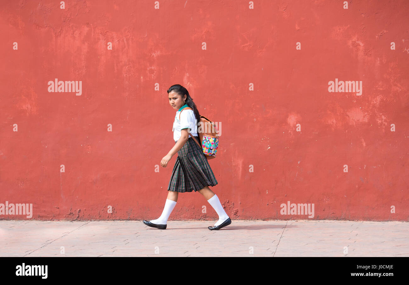 Valladolid, Mexico - Mar 14, 2017: Young girl in school uniform walking home after school hours. Stock Photo