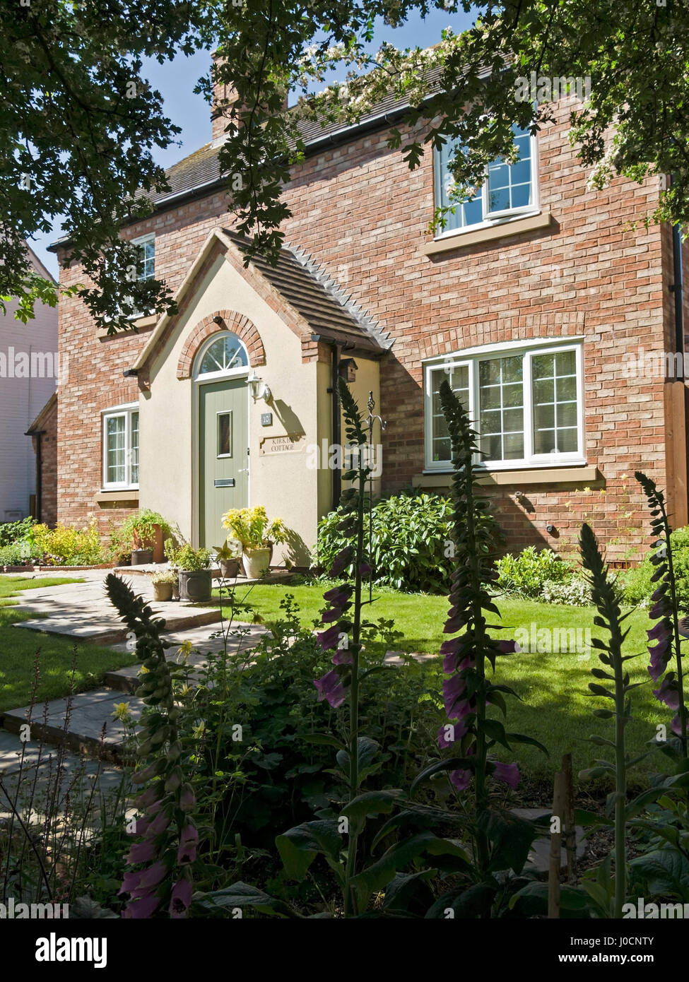 Modern cottage style house with porch and attractive front garden, England, UK Stock Photo